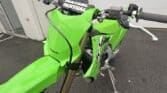 Kawasaki KX250X off-road motorcycle in bright green, ready for trail riding and motocross adventures.