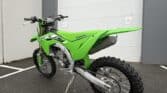 Green Kawasaki KX250X dirt bike parked outside Squamish Motorsports.