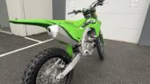Kawasaki KX250X dirt bike with rugged tires and green body, ideal for off-road adventures.
