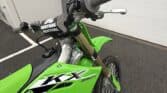 KX250X motocross bike with green body and black accents, ready for off-road adventures.